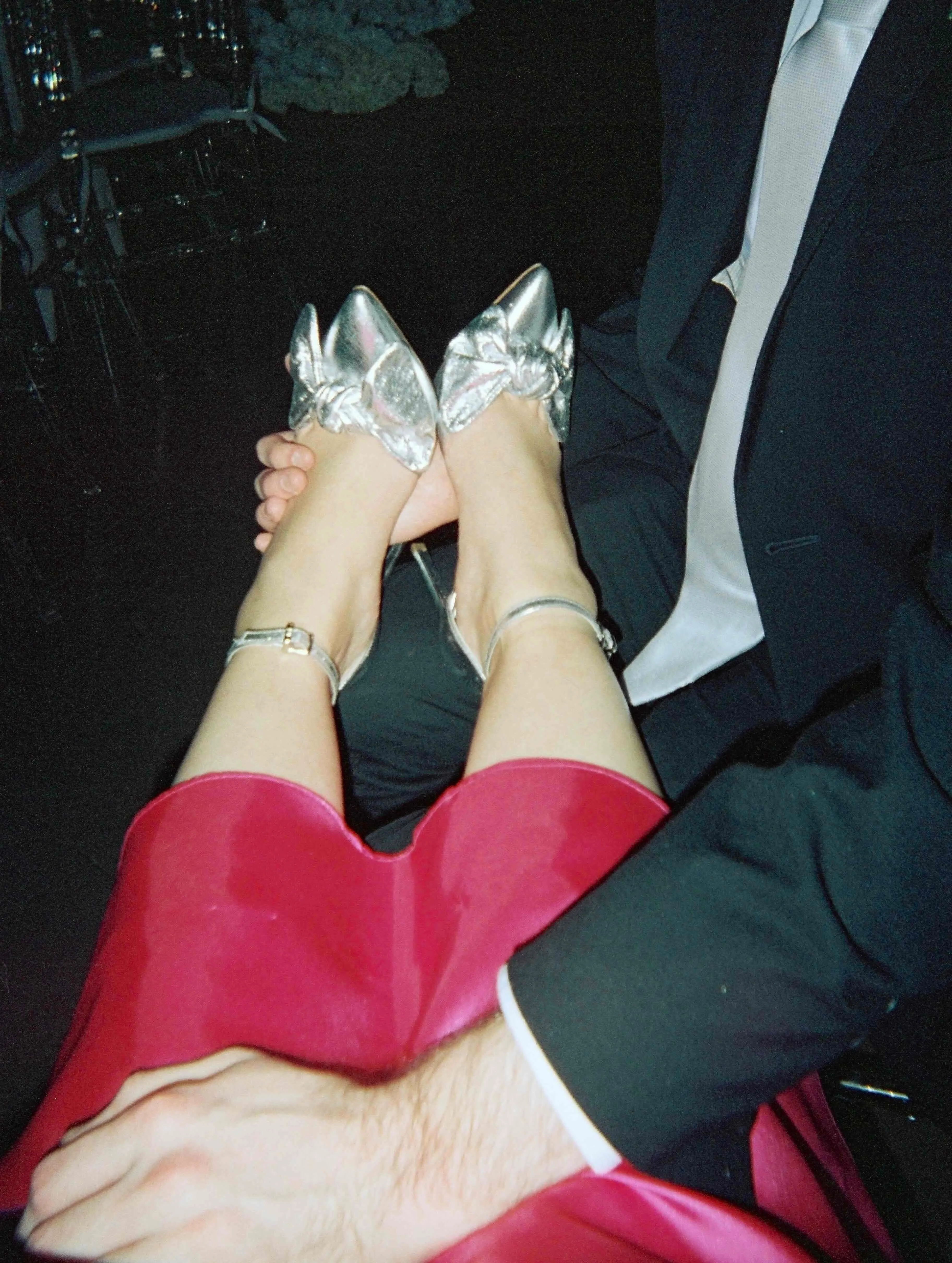 A man holding his partner's feet with silver heels