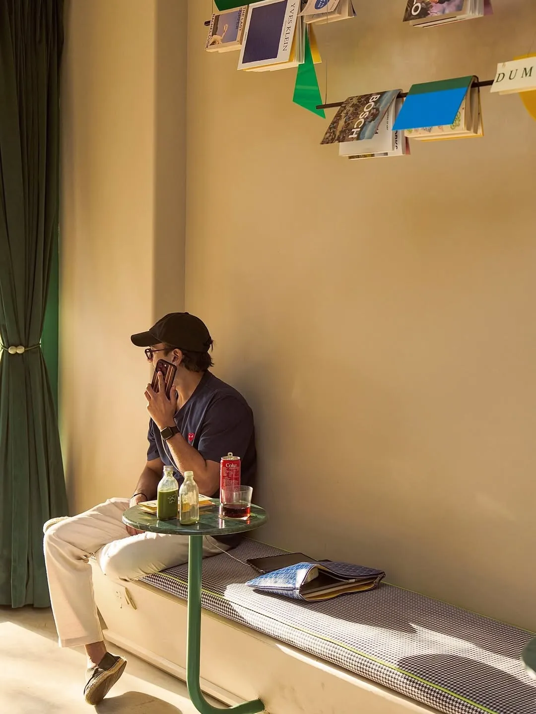 A picture of a man sitting at a brightly lit cafe, Dumbo Deli, which caters to cafe culture in India during the day and converts into a bar to cater to include bar culture India and function to both urban dining trends India, and community spaces in India