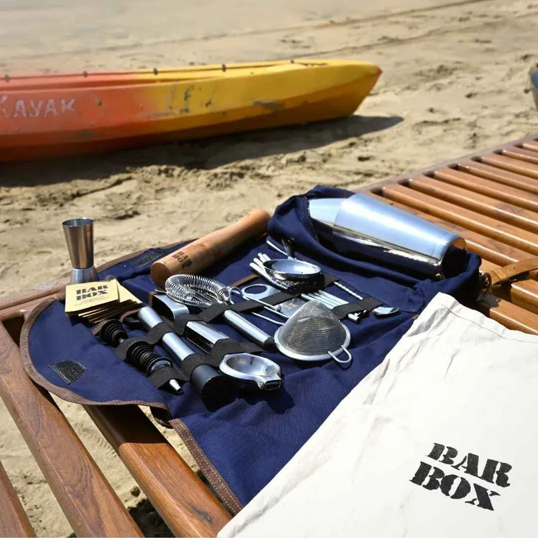 A picture of a travel-friendly cocktail equipment at home on the beach by brands like bar box to show the growing market for home bar essentials and bar tools for home as people invest in home bar cost with premium barware India