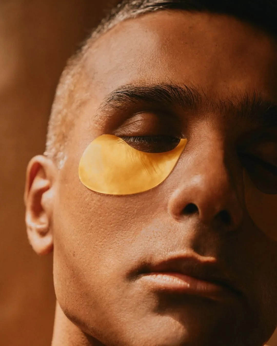 A man with a golden eye patch under his eyes