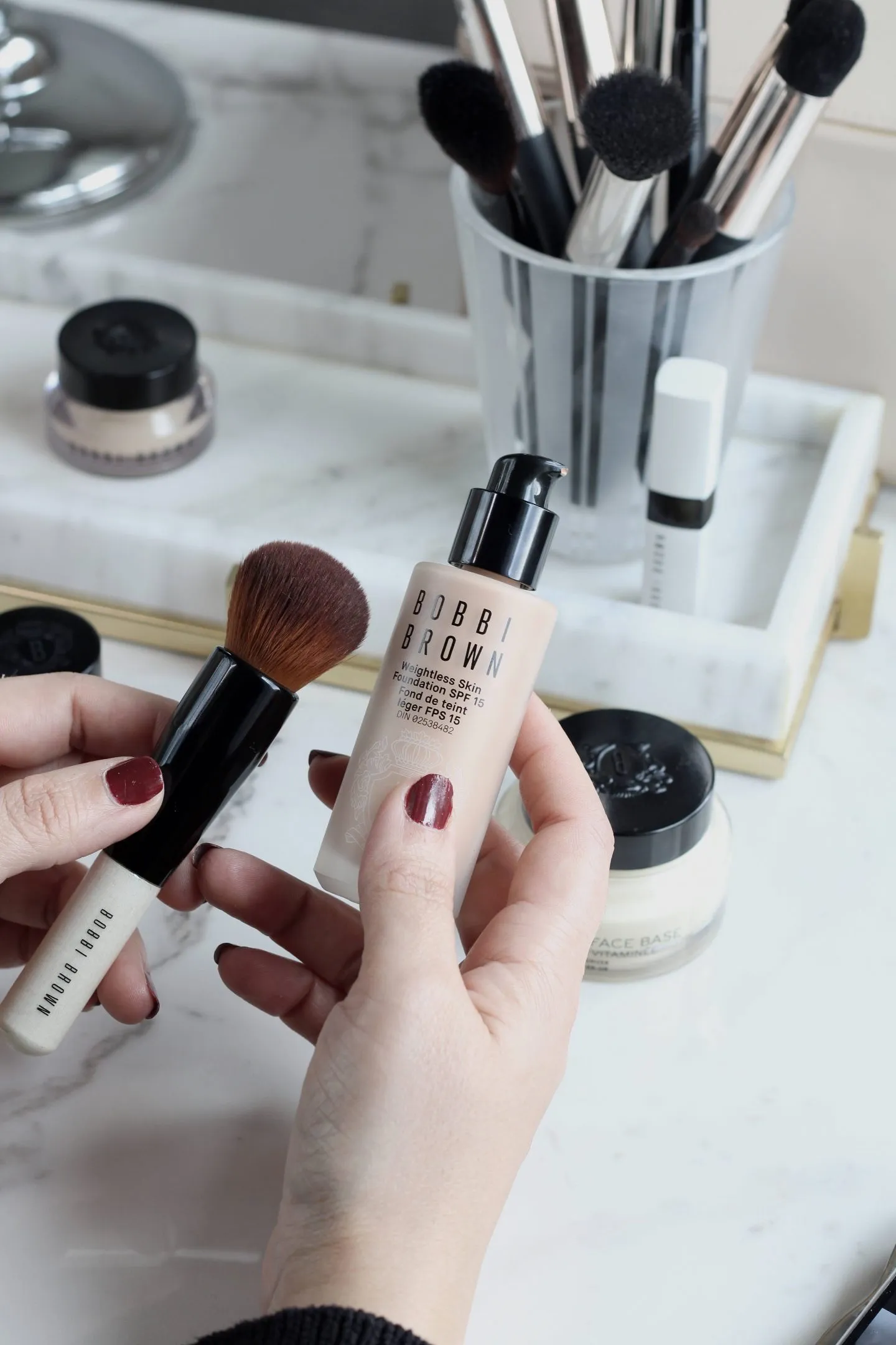 A bottle of Bobbi Brown foundation with SPF, which is the best foundation with SPF for oily skin, along with a foundation brush