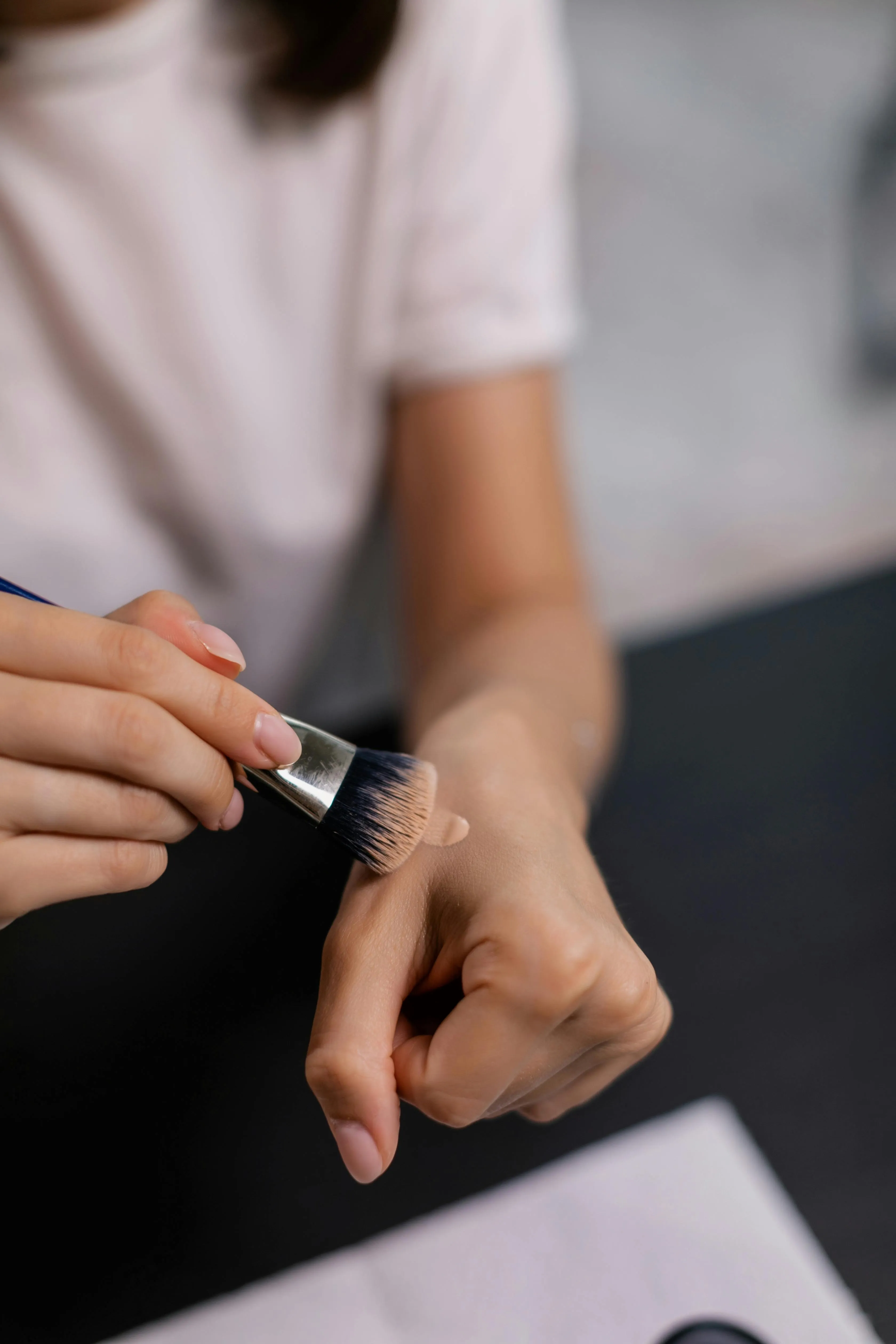 A woman swatching a foundation with SPF on her hand