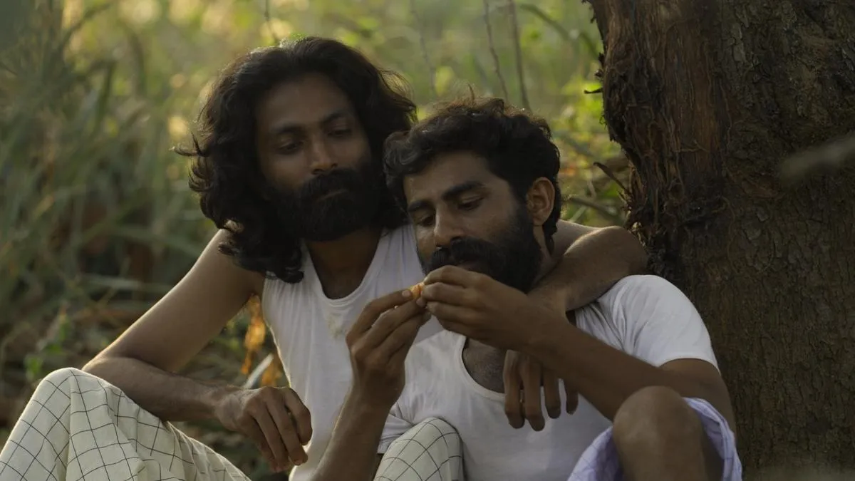 A still from Jijo Jessy Kuriakose's Velipadu (The Revelation) with two men speaking to each other in a public setting to show how queer filmmakers in India are making queer representation in Indian cinema common