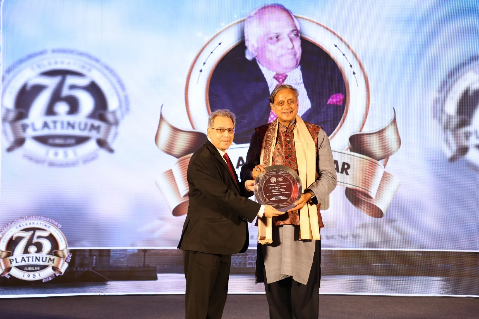 Mr Jimmy Shaw, President, HRAWI accepts the Lifetime Achievement Award from Dr Shashi Tharoor on Dr Ajit B Kerkar’s behalf