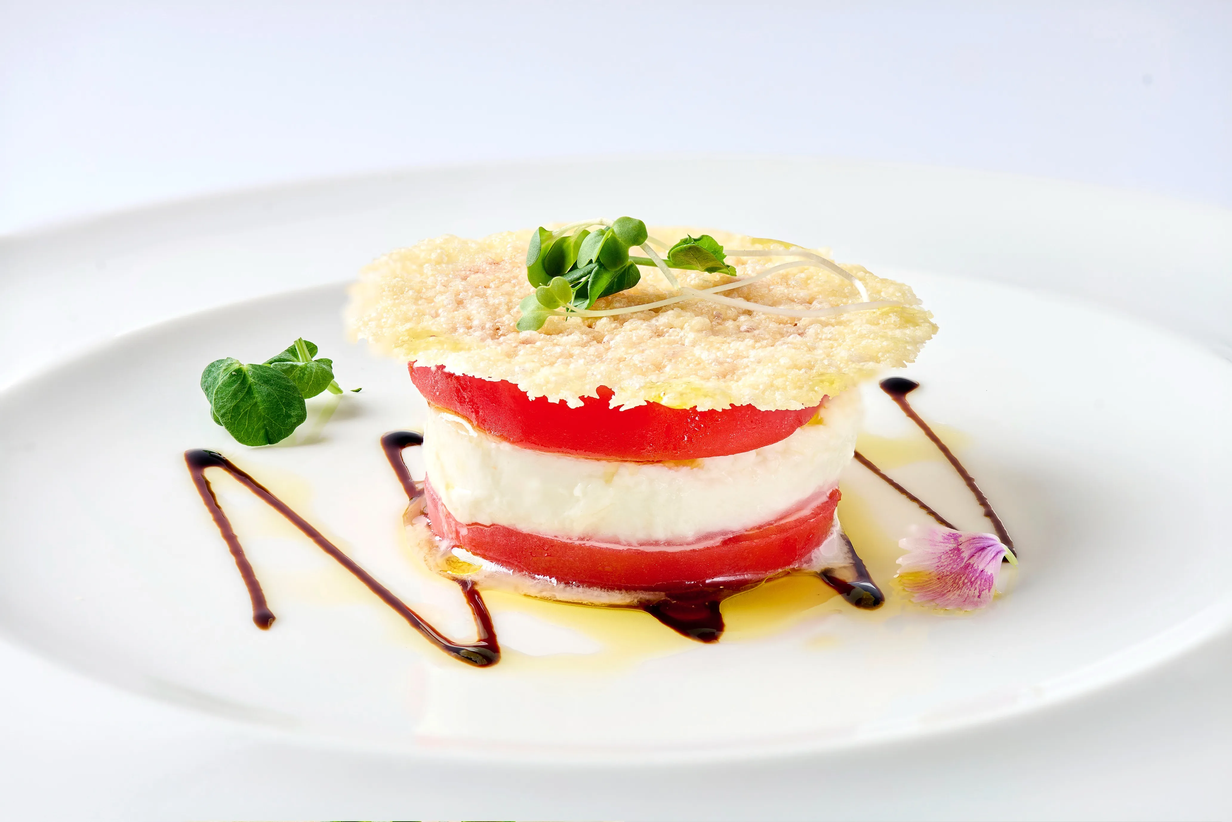 Buffalo mozzarella and confit fresh heirloom tomato drizzled with extra virgin olive oil from Sicily and balsamic reduction