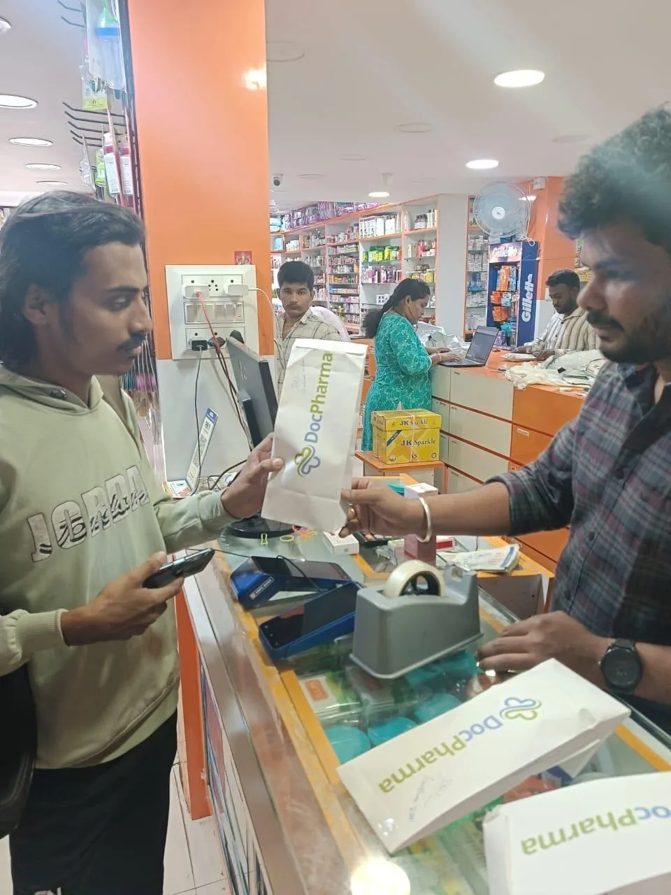 Pharmacist giving DocPharma bag to a delivery boy