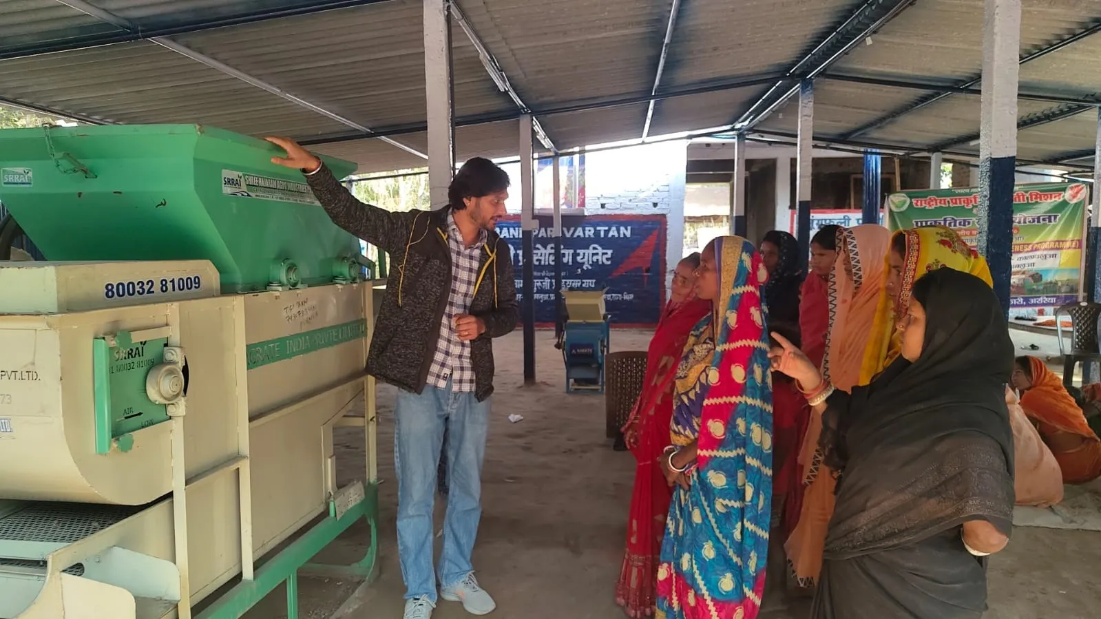 Prince Shukla demonstrates modern peanut shelling machine technology to local women farmers