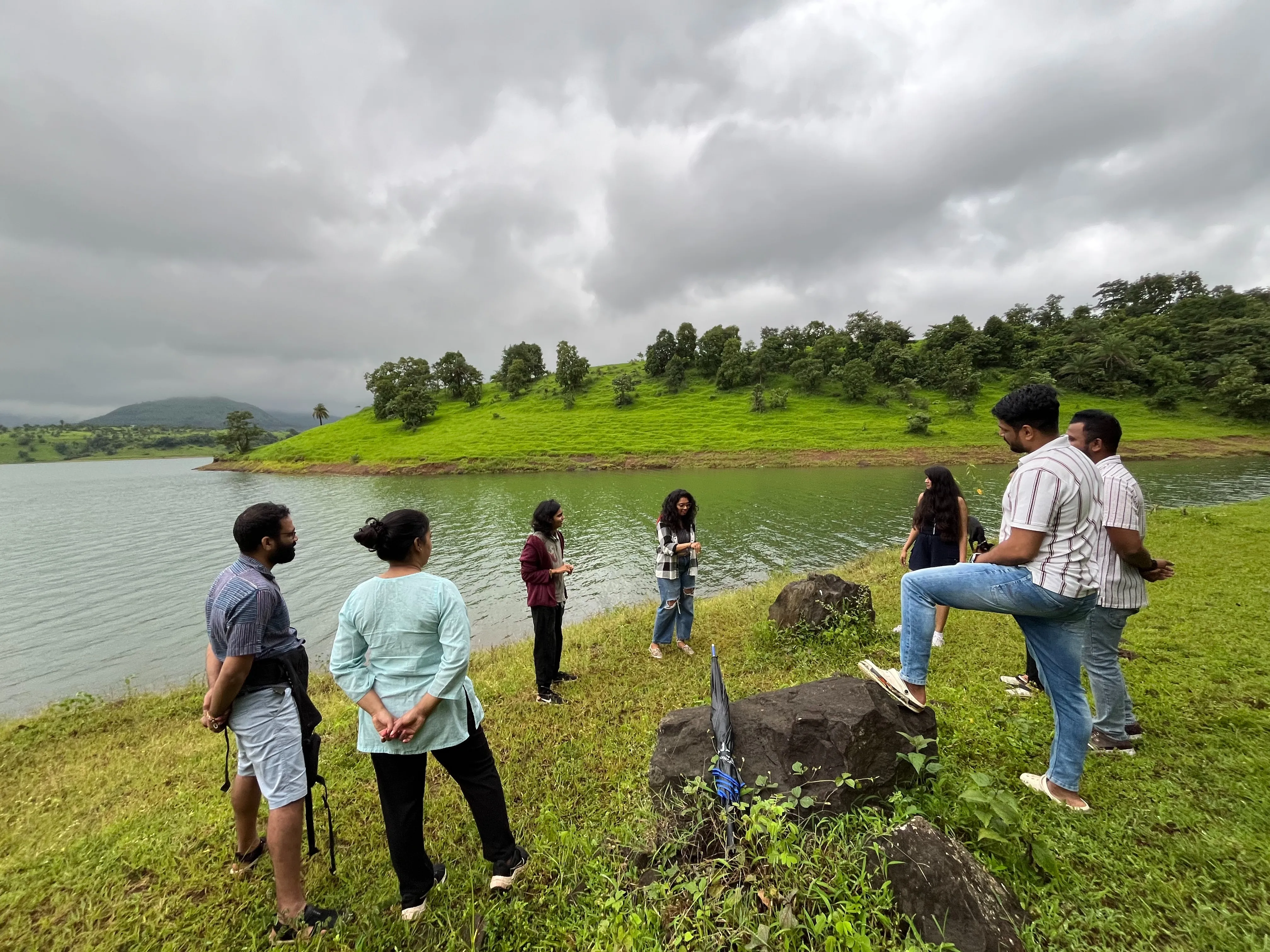 Friends and family gathered by the beautiful Bhama Askhed Dam backwaters at BaapBeti Permaculture Farm
