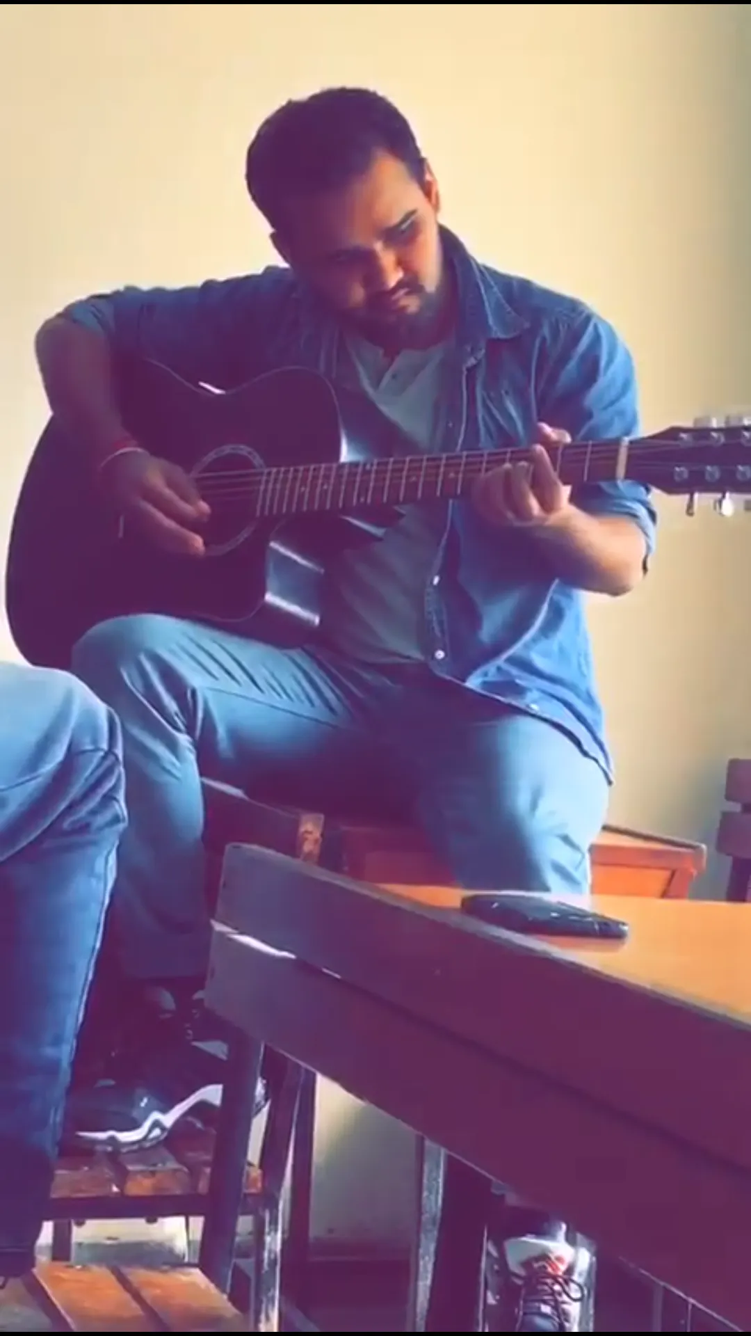A candid moment of Deepak playing an acoustic guitar during his college days