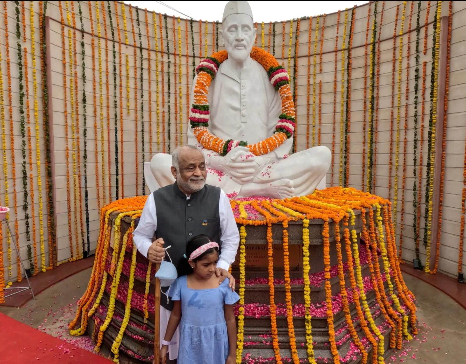 बाबूजी महराज की प्रतिमा के समक्ष कन्या को दुलार करते दाजी