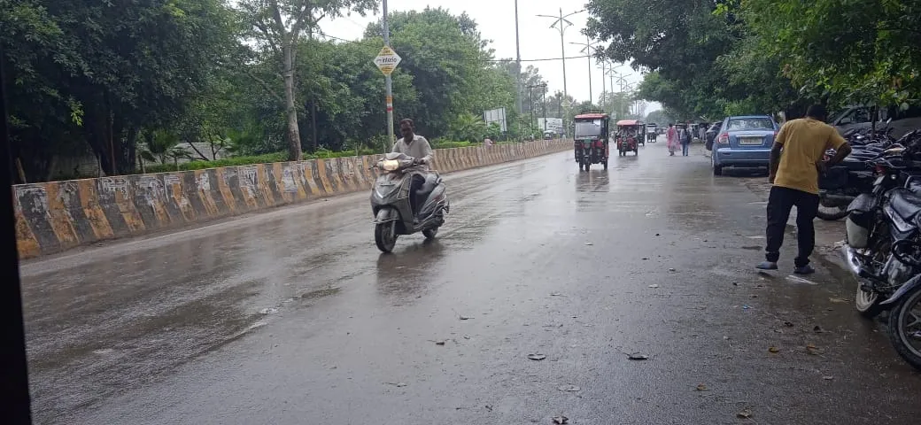 शाहजहांपुर में हल्की वर्षा के बीच जाते लोग
