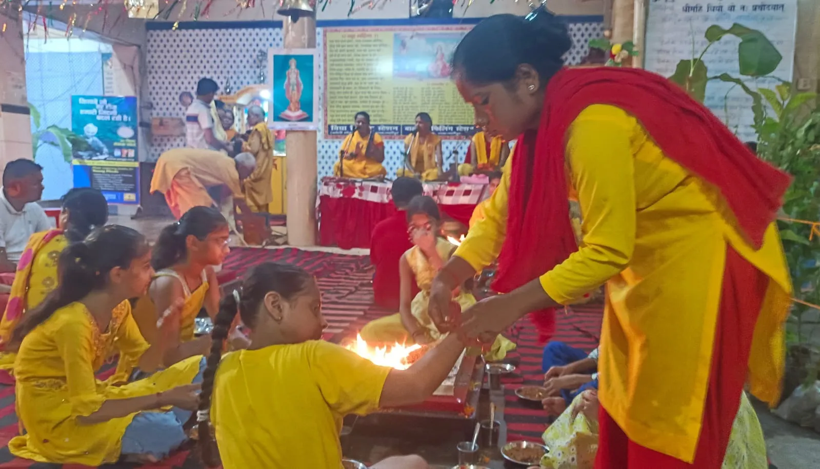 गुरू पूर्णिमा के अवसर पर हवन कर रही कन्याओं के रक्षा सूत्र बांधती
