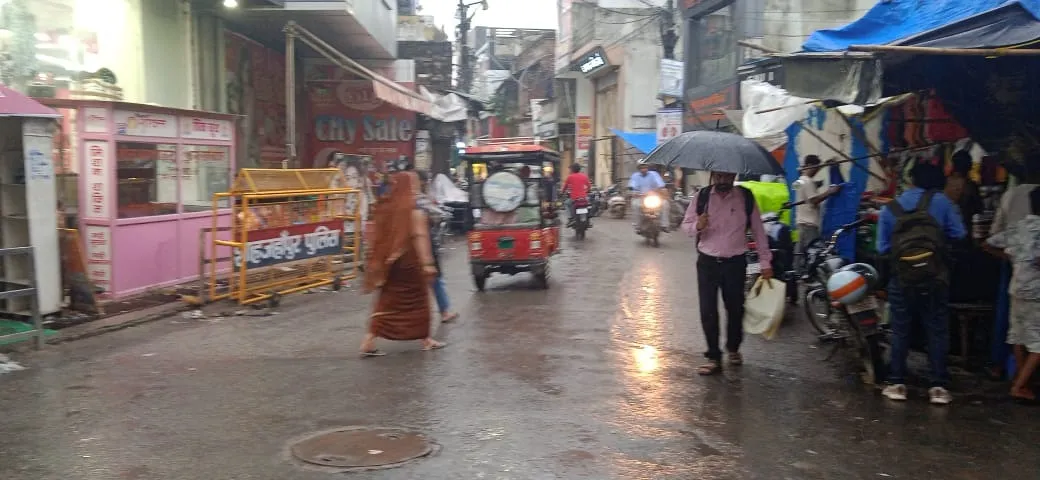 शाहजहांपुर में वर्षा की बीच जाते लोग