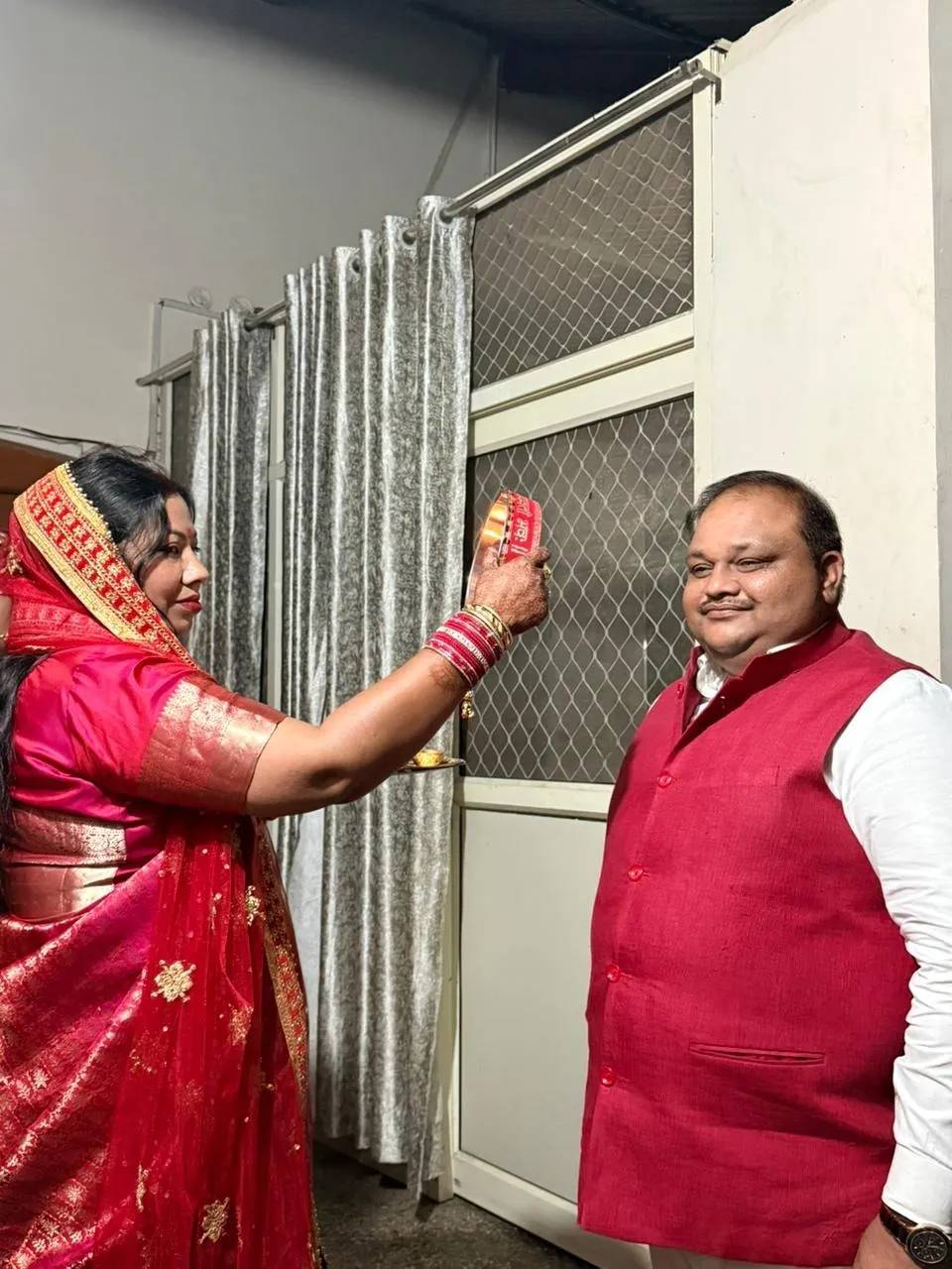 विधायक अरविंद सिंह के चलनी से दर्शन करती उनकी पत्नी बेबी सिंह