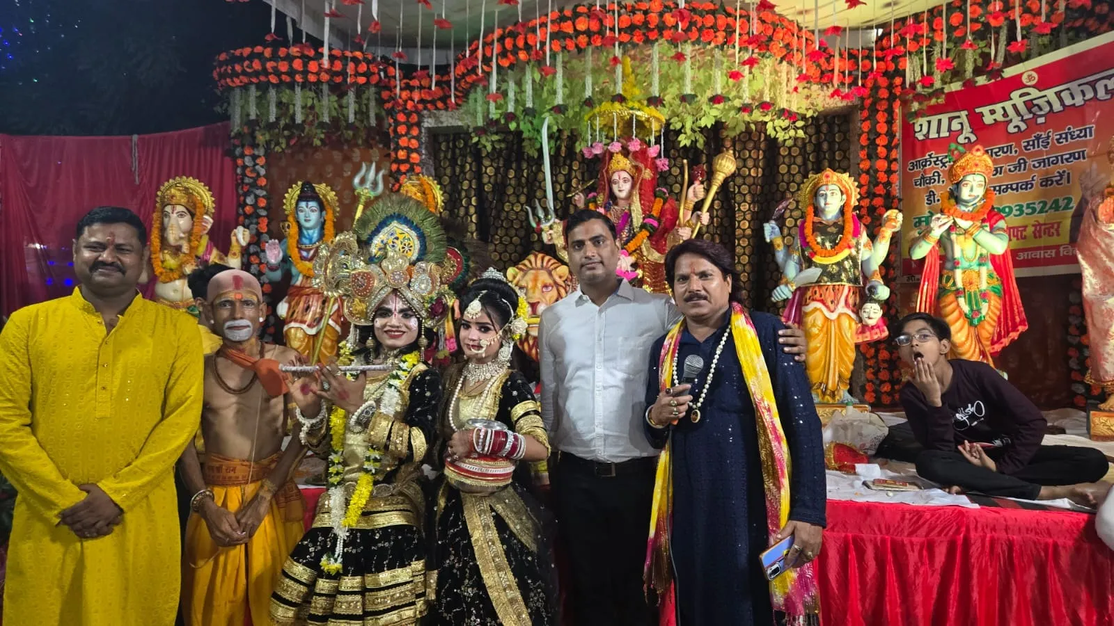 आवास विकास कालोनी में आयोजित जगराते में भव्य रूप से सजे दरबार में राधा कृष्ण की झांकी के साथ आयोजक अमित यादव, संजू यादव व भजन गायक नरेंद्र शानू