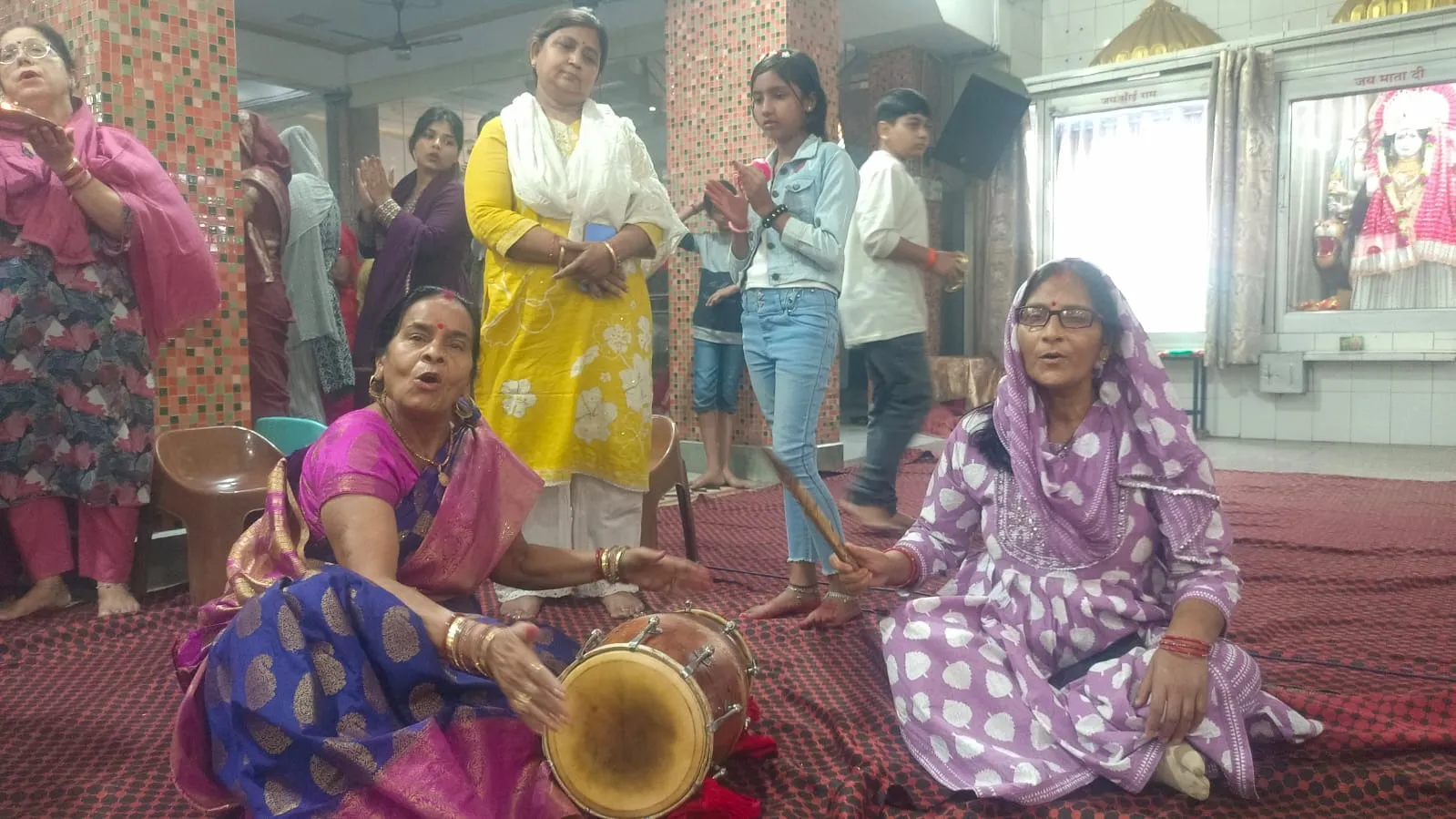 कृष्णा नगर मंदिर में ढोलक की थाप संग गोवर्धन भगवान के भजन गाती महिलाएं