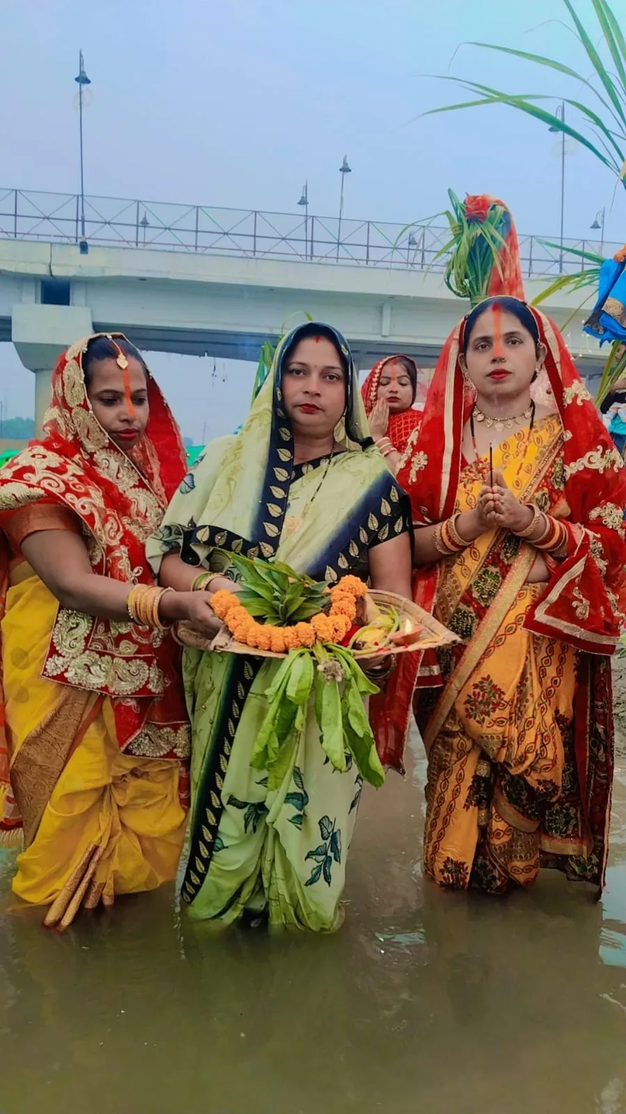 सूर्य देव को अर्घ्य देने को जल में खडी सुहागिने