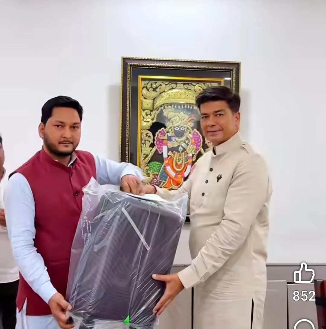 मेयर उमेश गौतम से नोटों का लिफाफा और अटैची लाल सदरी पहनकर ग्रहण किया।