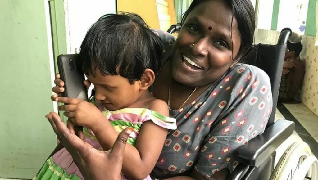 Premillam shelter home. Woman on wheelchair cuddling a child