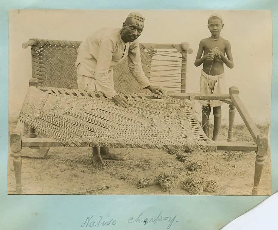 A photo of a charpoy being strung or restrung, from c.1900