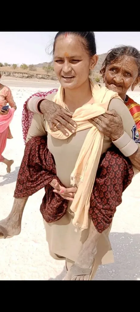 Constable varsha with old lady on her back in thar of Kutch