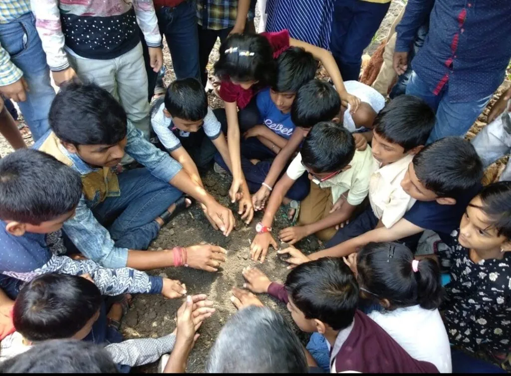 Children learning to make seed ball.