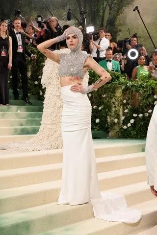 Image may contain Cara Delevingne Clothing Dress Fashion Formal Wear Gown Wedding Wedding Gown and Electrical Device