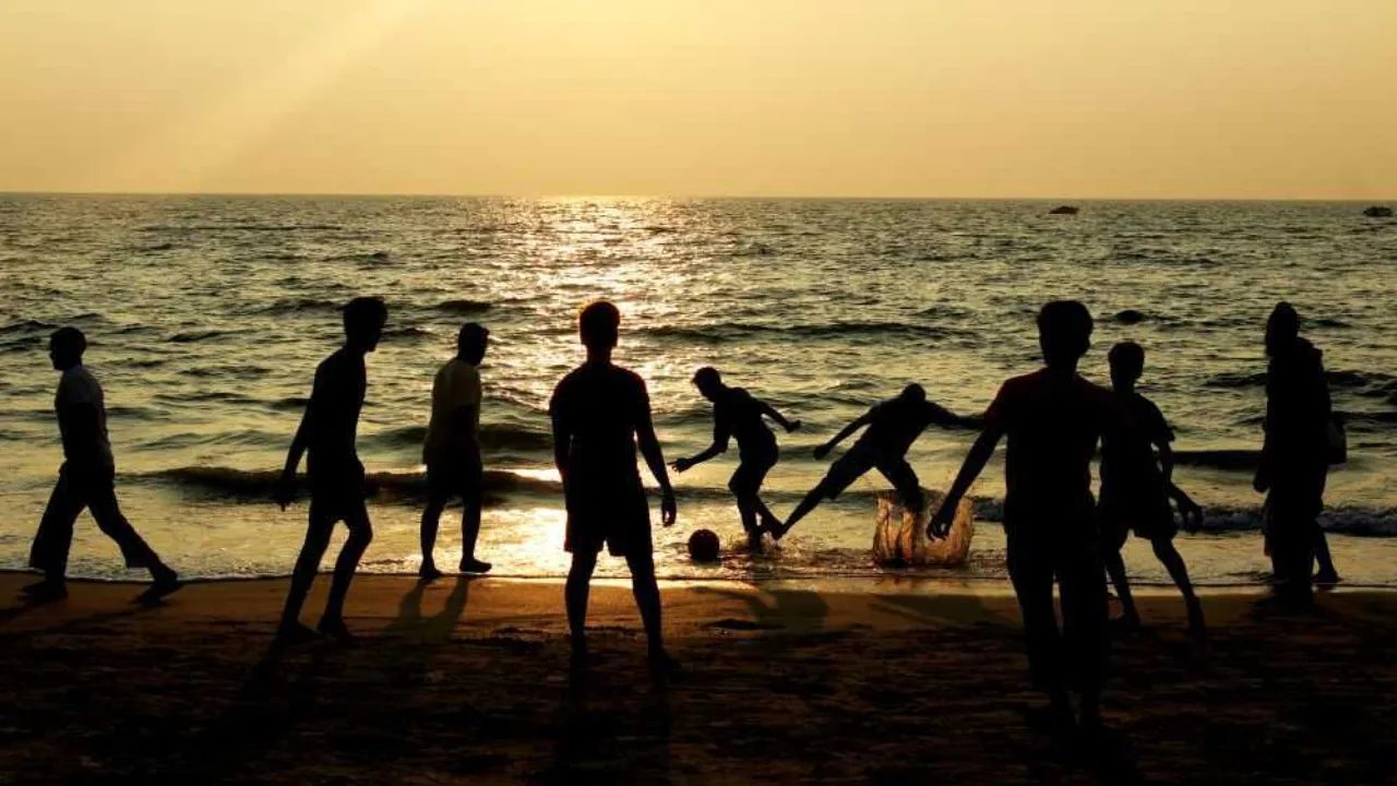 shilloutte of kids playing football on beach 