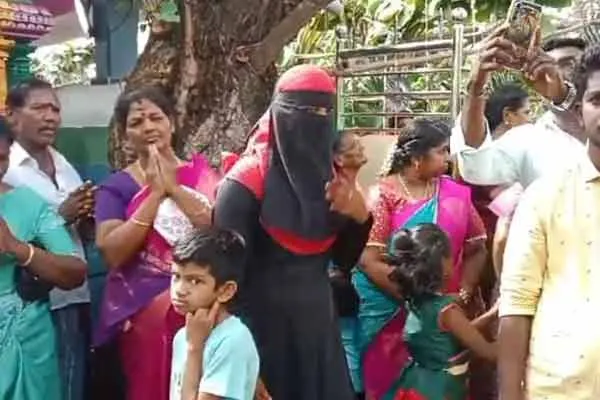 Muslim woman bowing in worship at the Veeramuni Andavar temple.