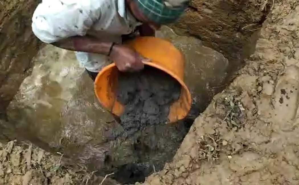 Concrete inside a water filled pit to build a government school perimeter wall
