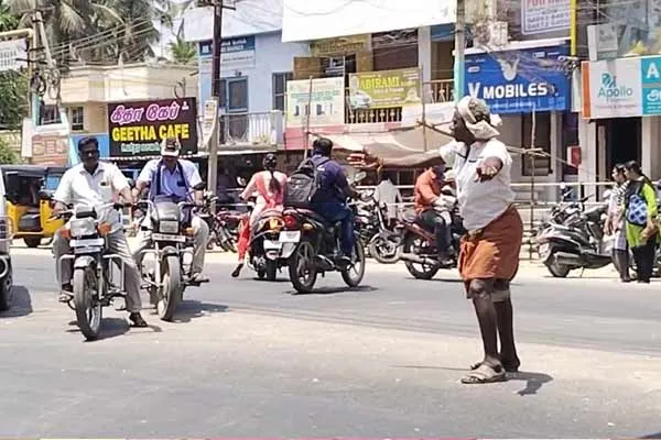  old man fixing the traffic in the hot sun 
