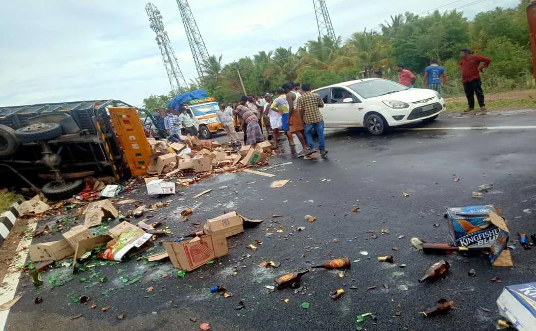truck carrying liquor met with an accident and people taking away the liquor bottles