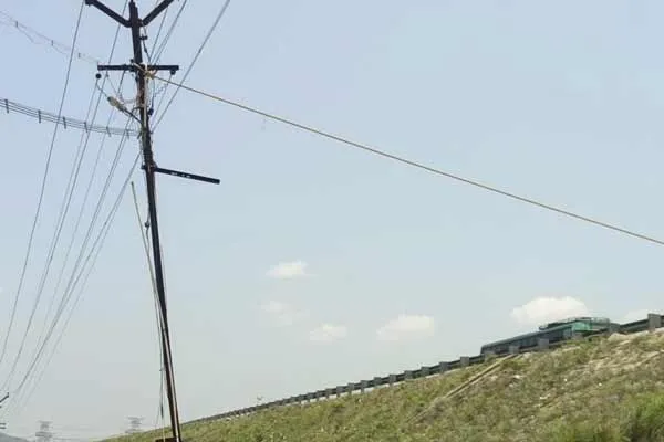 Power workers tied a rope to hold the falling power pole