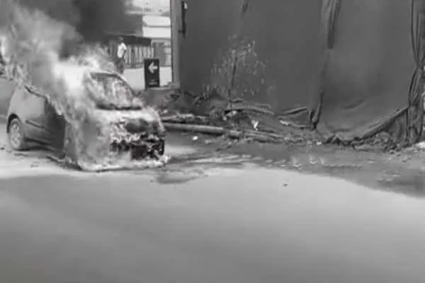 A burnt car about in the middle of the road; incident in Avadi