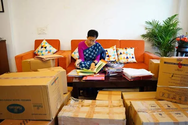 Adishi works sitting among the cartons