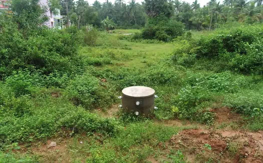 Young man storing wasted rainwater in an old well through pipes ...