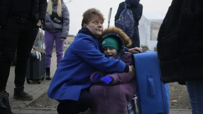 A woman holds a small girl at a border crossing in Medyka, Poland. (Photo: AP)