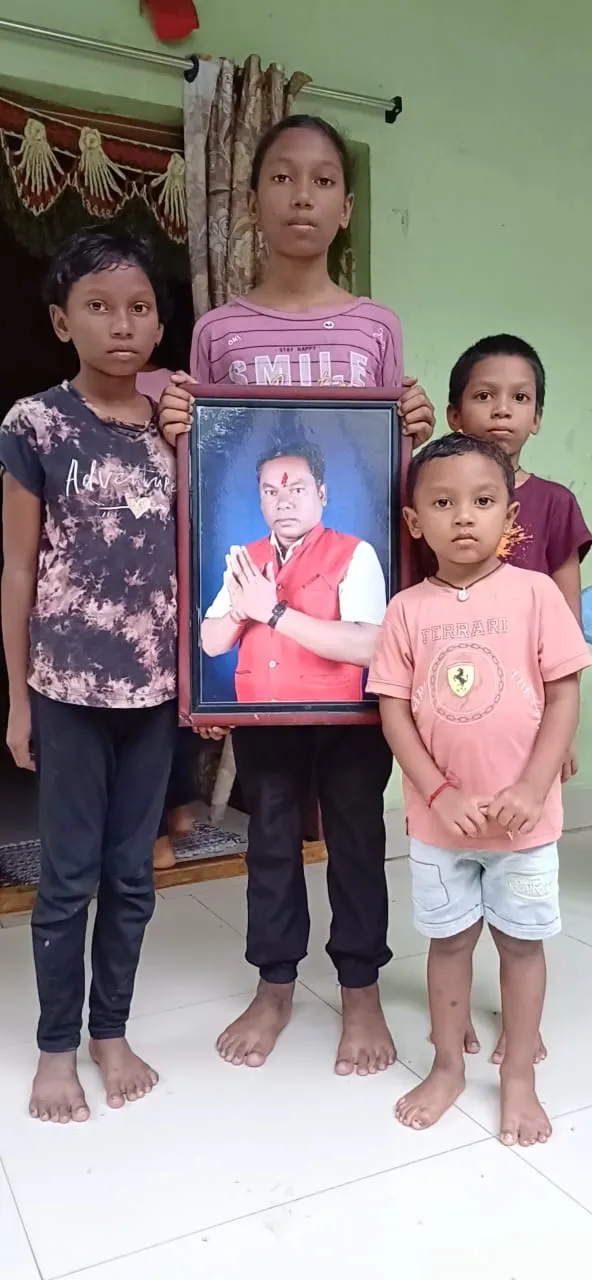 पिता की तस्वीर के साथ नीलकंठ कक्केम के बच्चे।