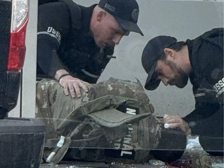 गोलीबारी में घायल गार्ड को देखते अन्य सुरक्षाकर्मी।