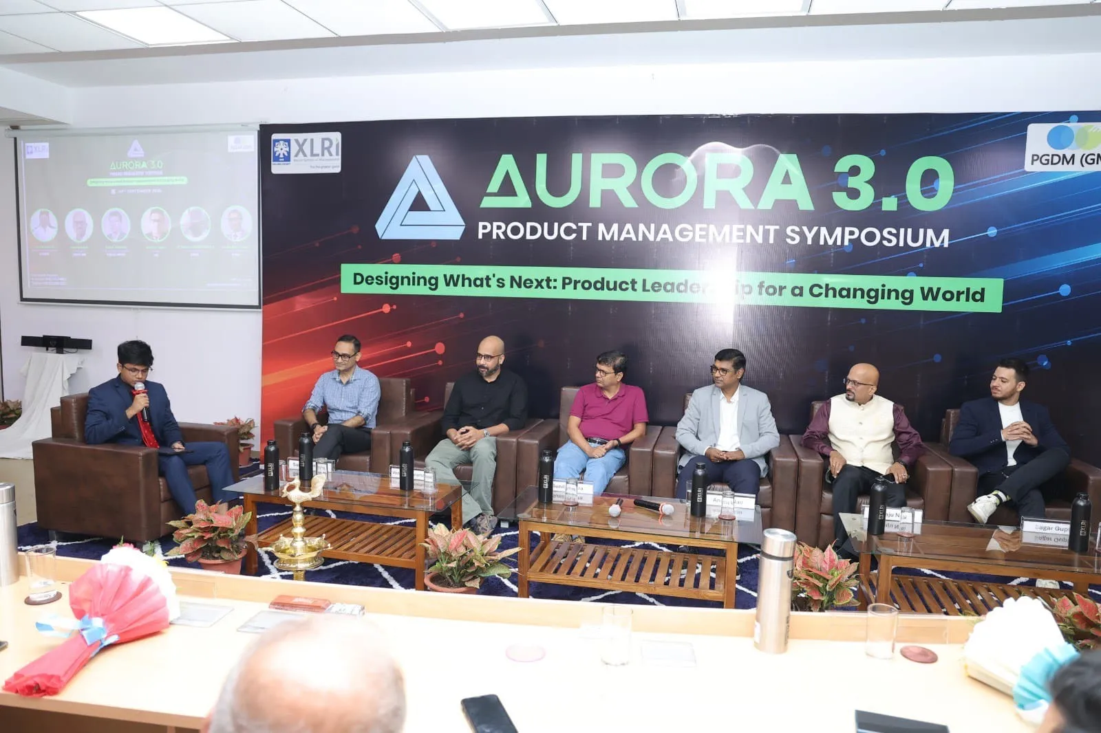 A group of people sitting on a stageAI-generated content may be incorrect.