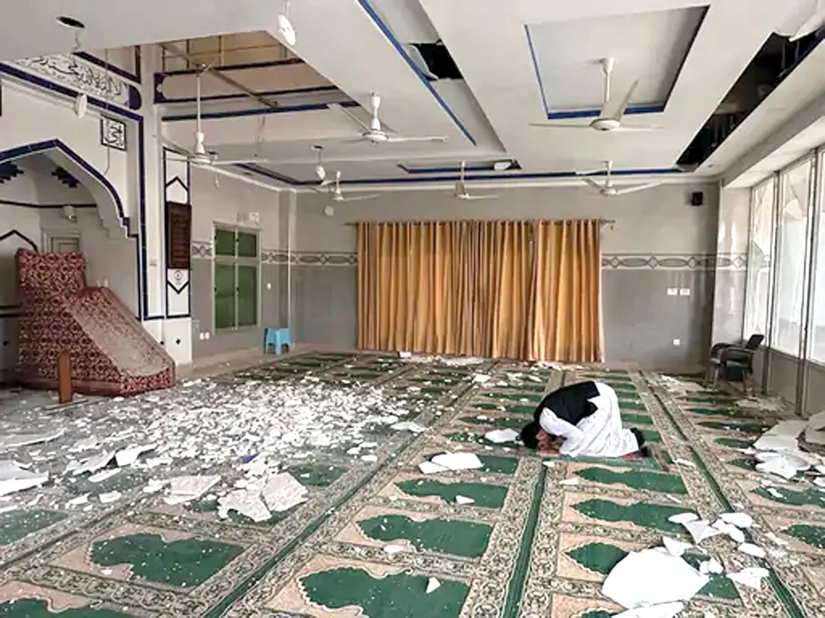 A man offers prayers at a damaged mosque