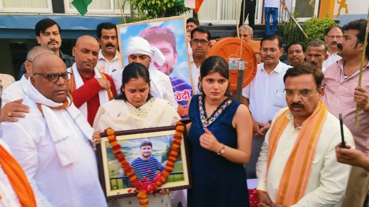 पति शुभम की तस्वीर लेकर यात्रा में शामिल हुईं उनकी पत्नी एशान्या।