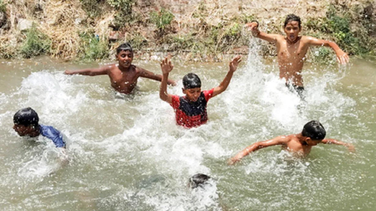 Young boys jump into a canal