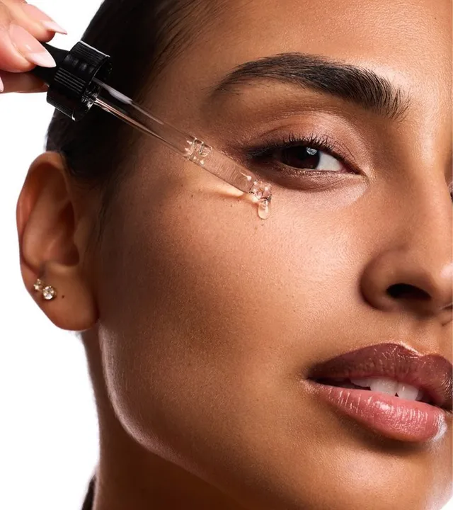 A woman applying a serum for sensitive skin type using a pipette