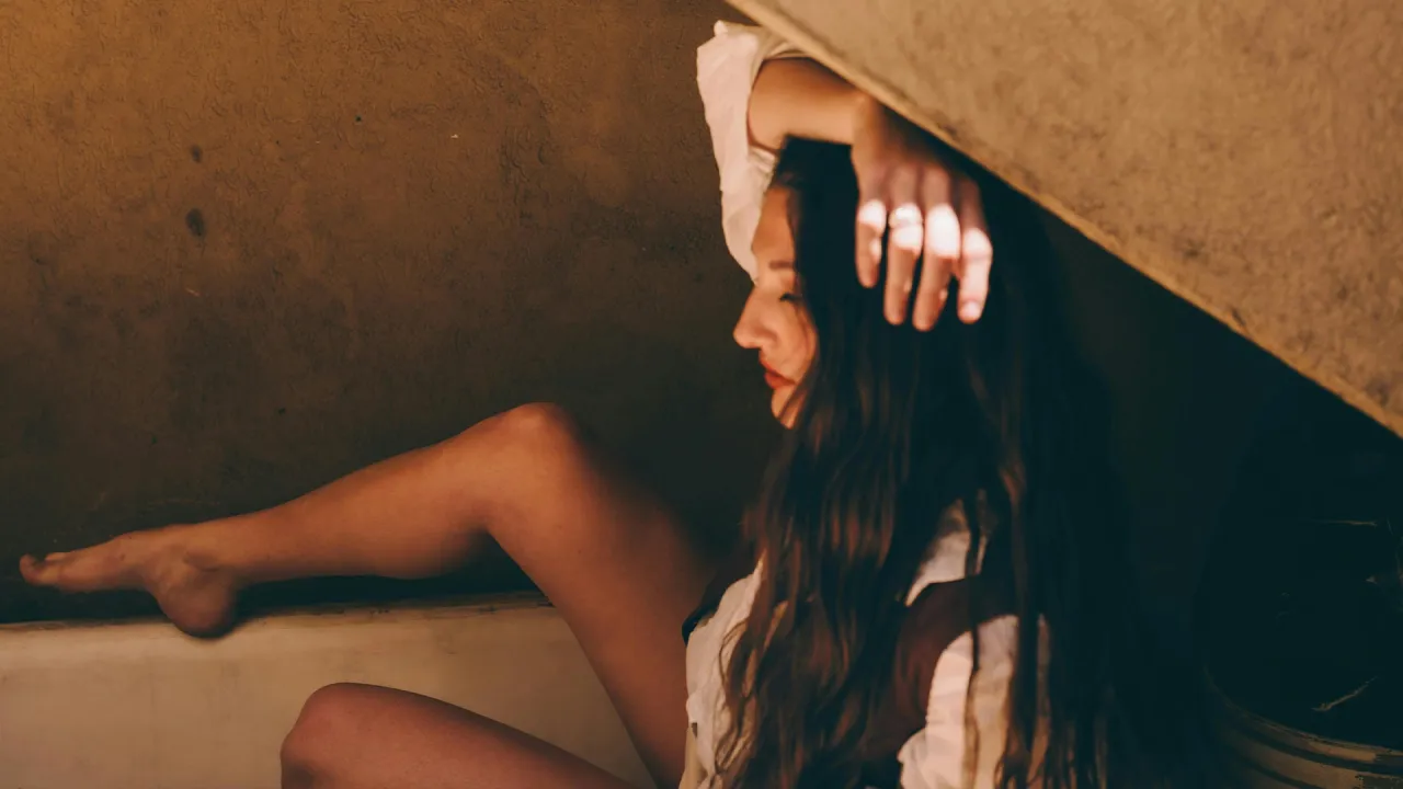 A seated woman with her hand on her hair