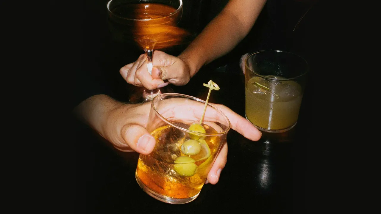 A picture of many people holding scotch cockatils in India to show how Indians drink whisky and Scotch