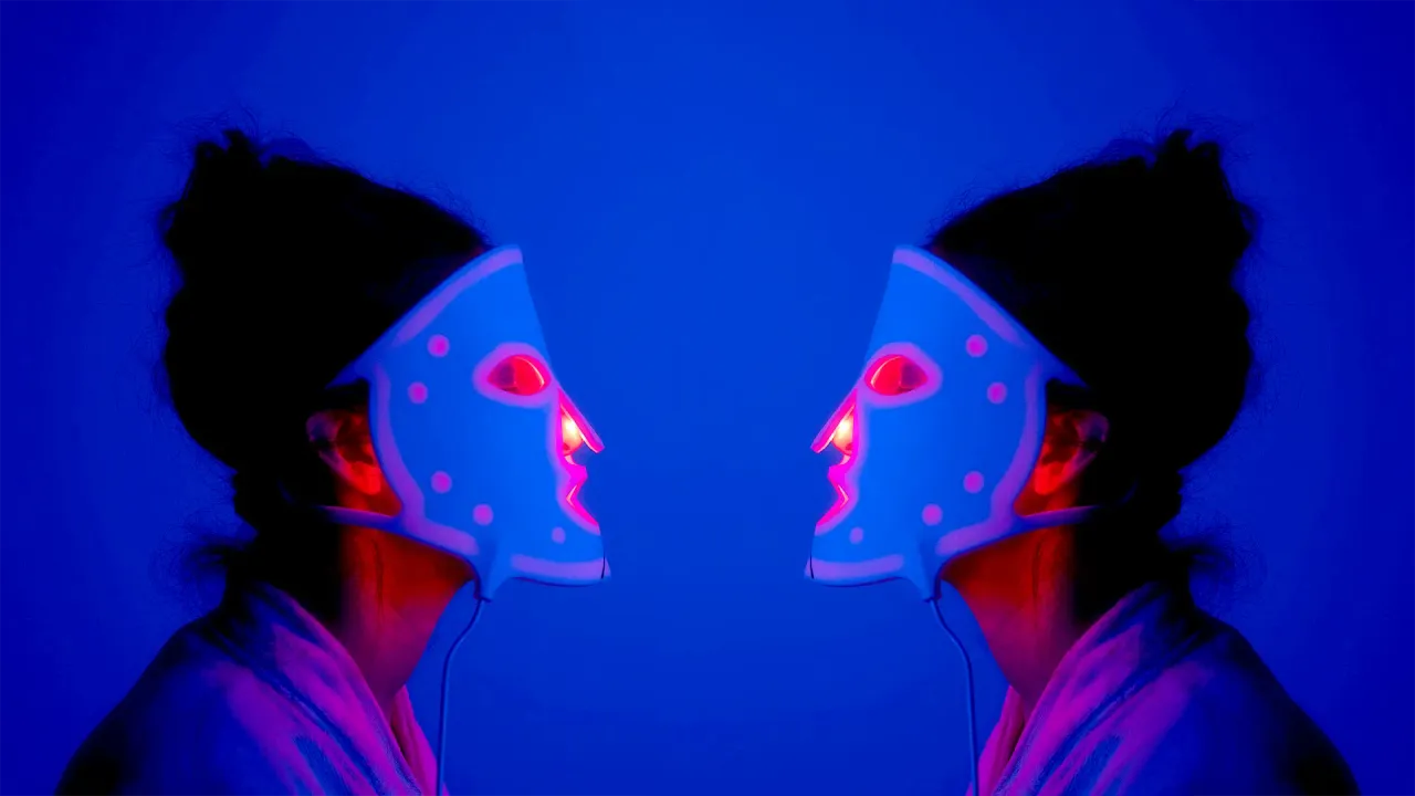  Two women in LED masks sitting facing each other 