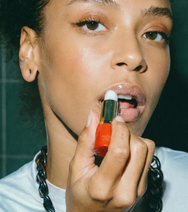 A woman applying the best lip balm in India