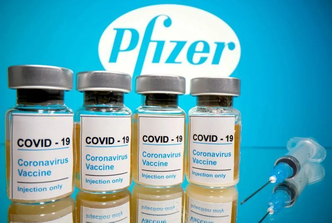  FILE PHOTO: Vials with a sticker reading "COVID-19 / Coronavirus vaccine / Injection only" and a medical syringe are seen in front of a displayed Pfizer logo in this illustration taken October 31, 2020. REUTERS/Dado Ruvic/File Photo/File Photo 