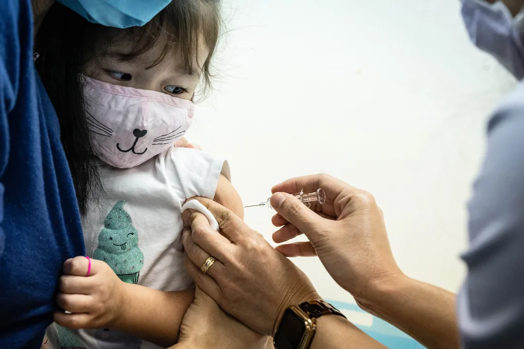  A child receives a shot of influenza vaccine at a clinic in Hong Kong, China, on Tuesday, Nov. 17, 2020. The coronavirus pandemic has brought new urgency to this year's influenza season, which typically kicks off in October and peaks in the winter months. Influenza and the coronavirus are respiratory illnesses that look similar, and both can be deadly, creating the threat of overwhelming hospitals. Photographer: Lam Yik/Bloomberg 